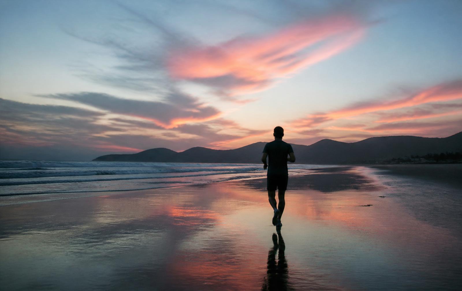 Corredor na praia ao amanhecer